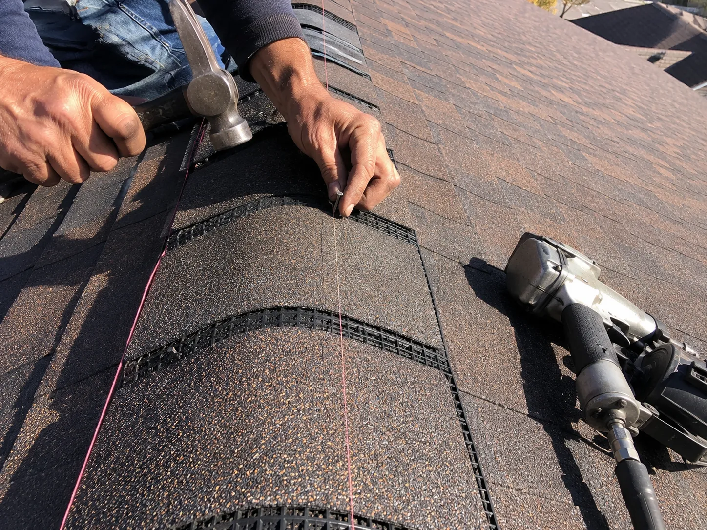 Ridge cap and ridge vent installation detail on an asphalt shingle roof