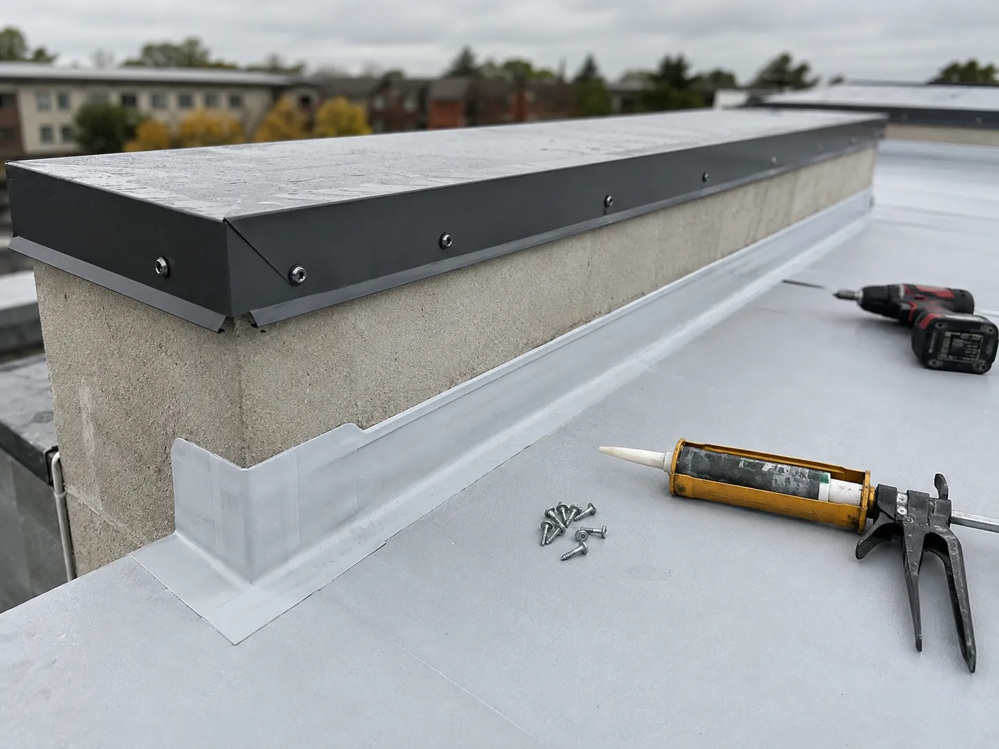 Parapet wall edge flashing installation detail on a flat roof
