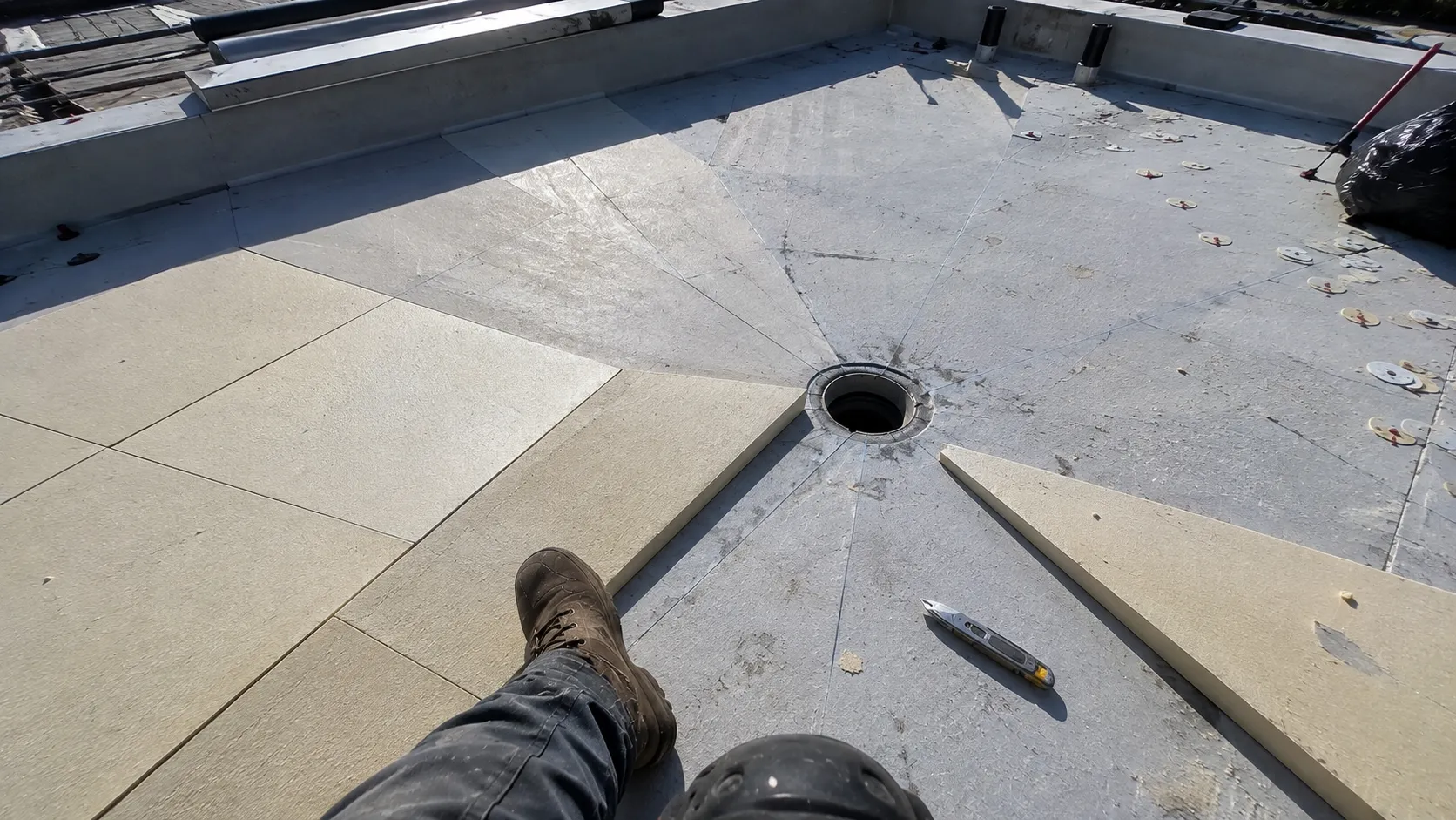 Tapered insulation installation correcting slope toward a flat roof drain